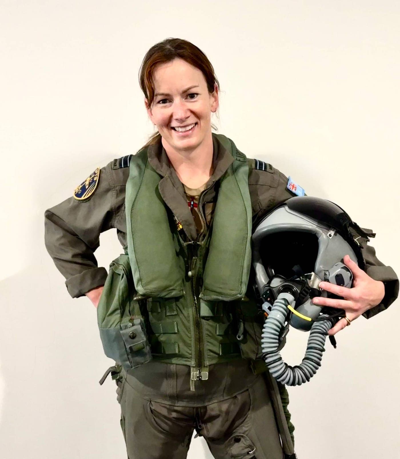 Steffanie Smith in flight gear, carrying her helmet