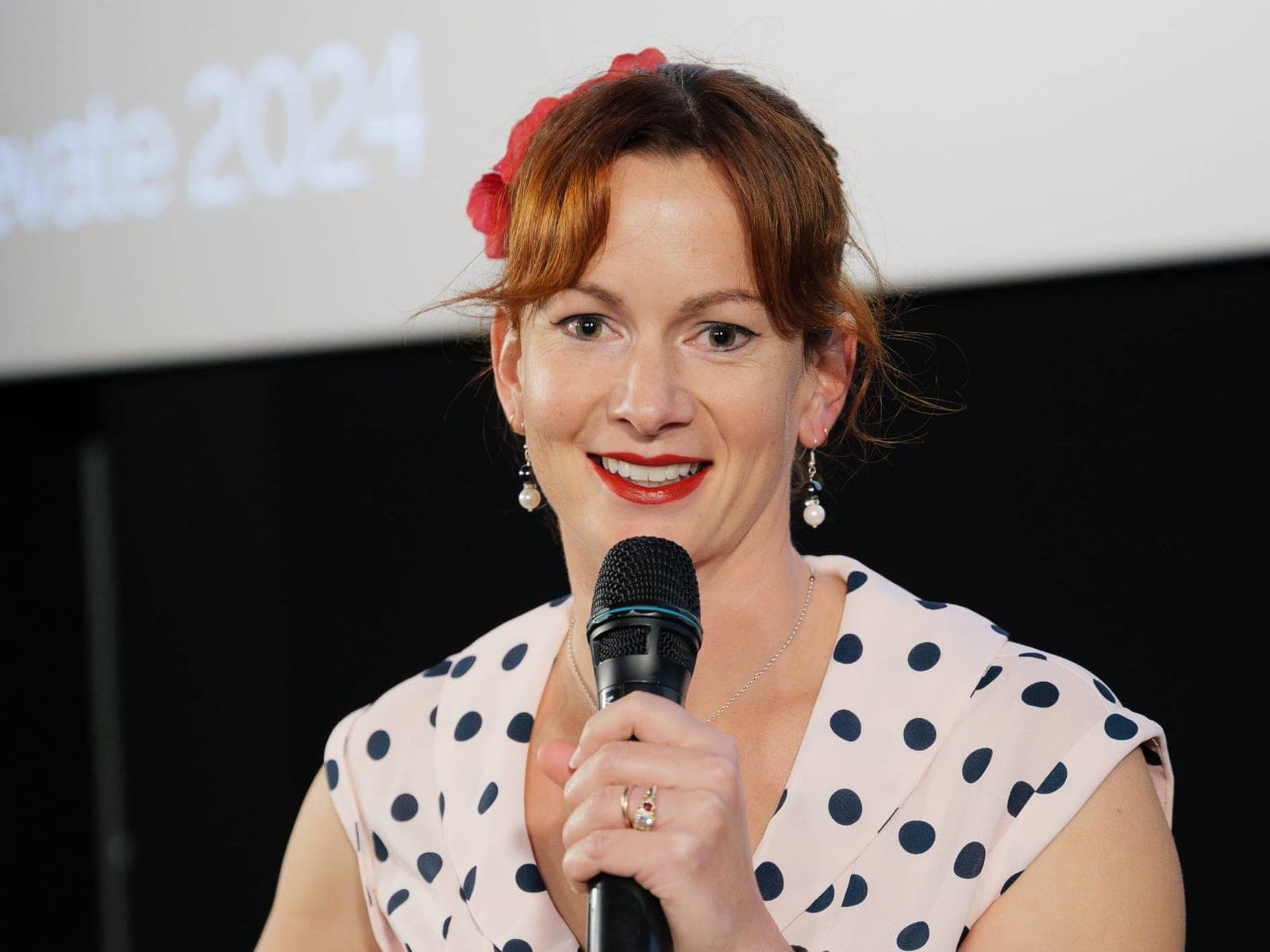 Steffanie Smith hosting an event, microphone in hand